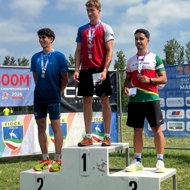 Alex Florindo on an obstacle course racing podium with his medal